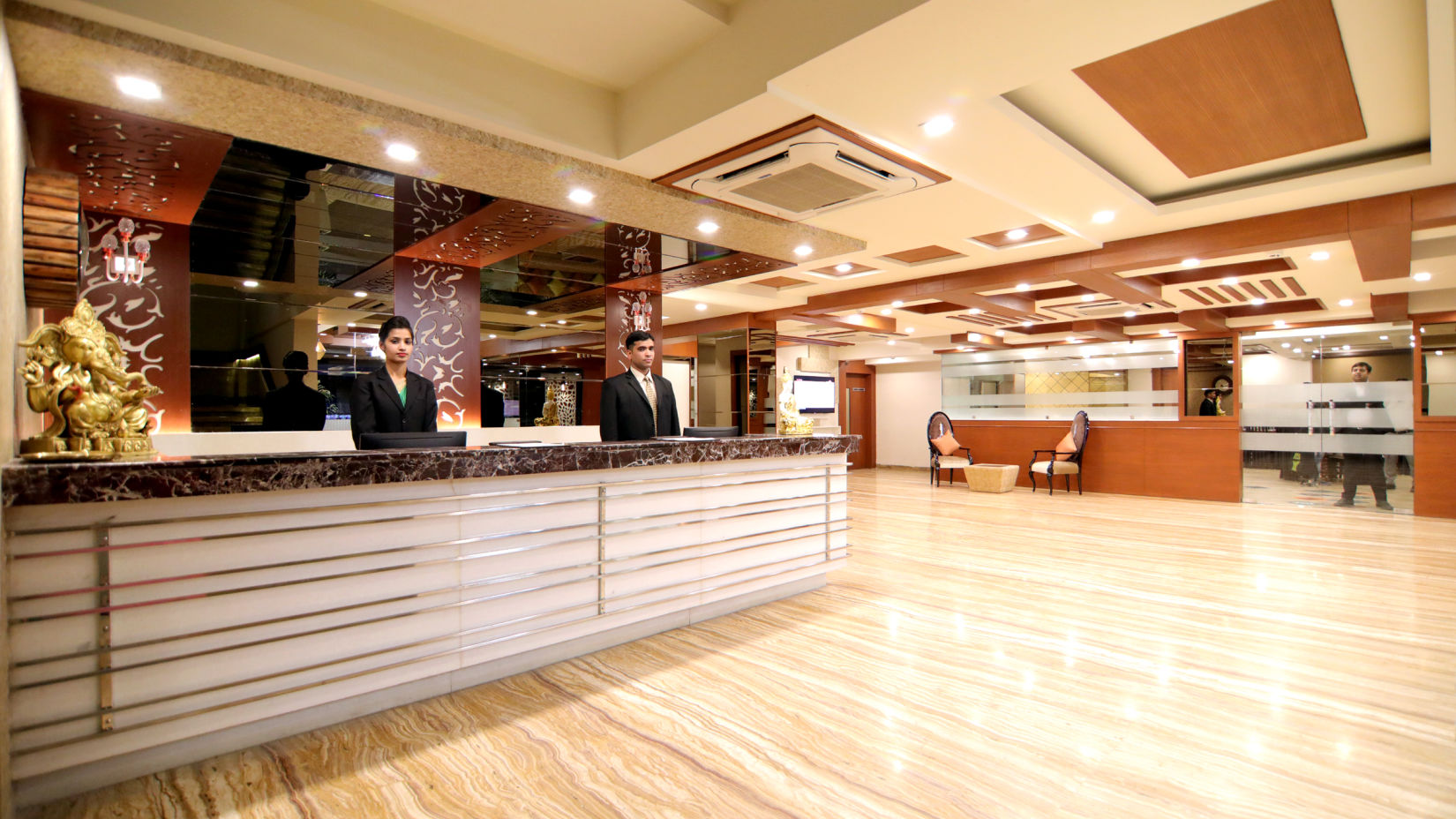 A person standing behind the counter at the Reception - Udman Hotel Haridwar