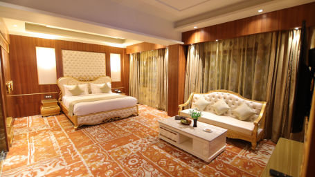 The Royal Suite features a bed and a white sofa 2 - Udman Hotel Haridwar