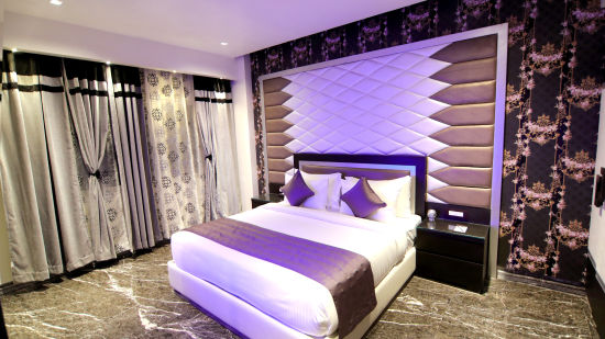 The elegant bedding and aesthetic walls of the Junior Suite - Theme Modern 3 - Udman Hotel Haridwar
