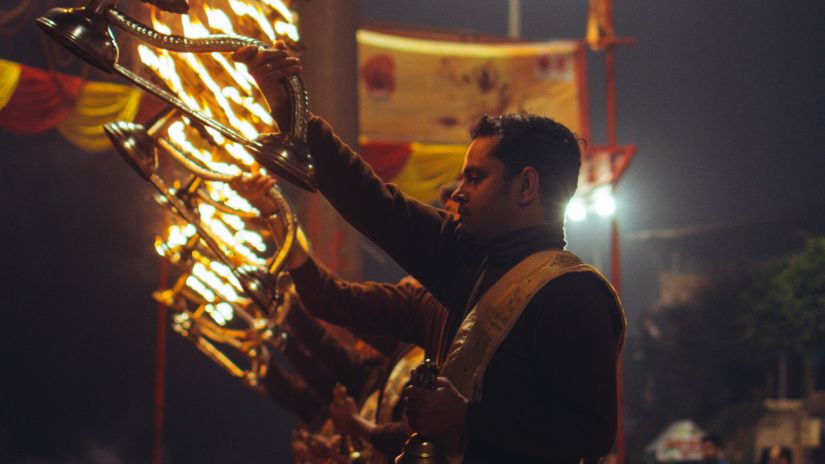 Person knelling down and performing a ritual with lights