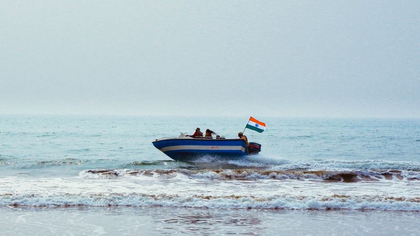 A motor boat goes by on the beach near the Puri to Konark Marine Drive