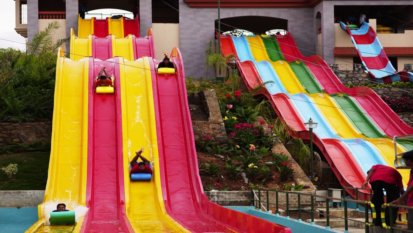 People sliding down multi-coloured water slides