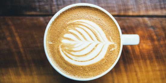 an image of a coffee cup with flower coffee art