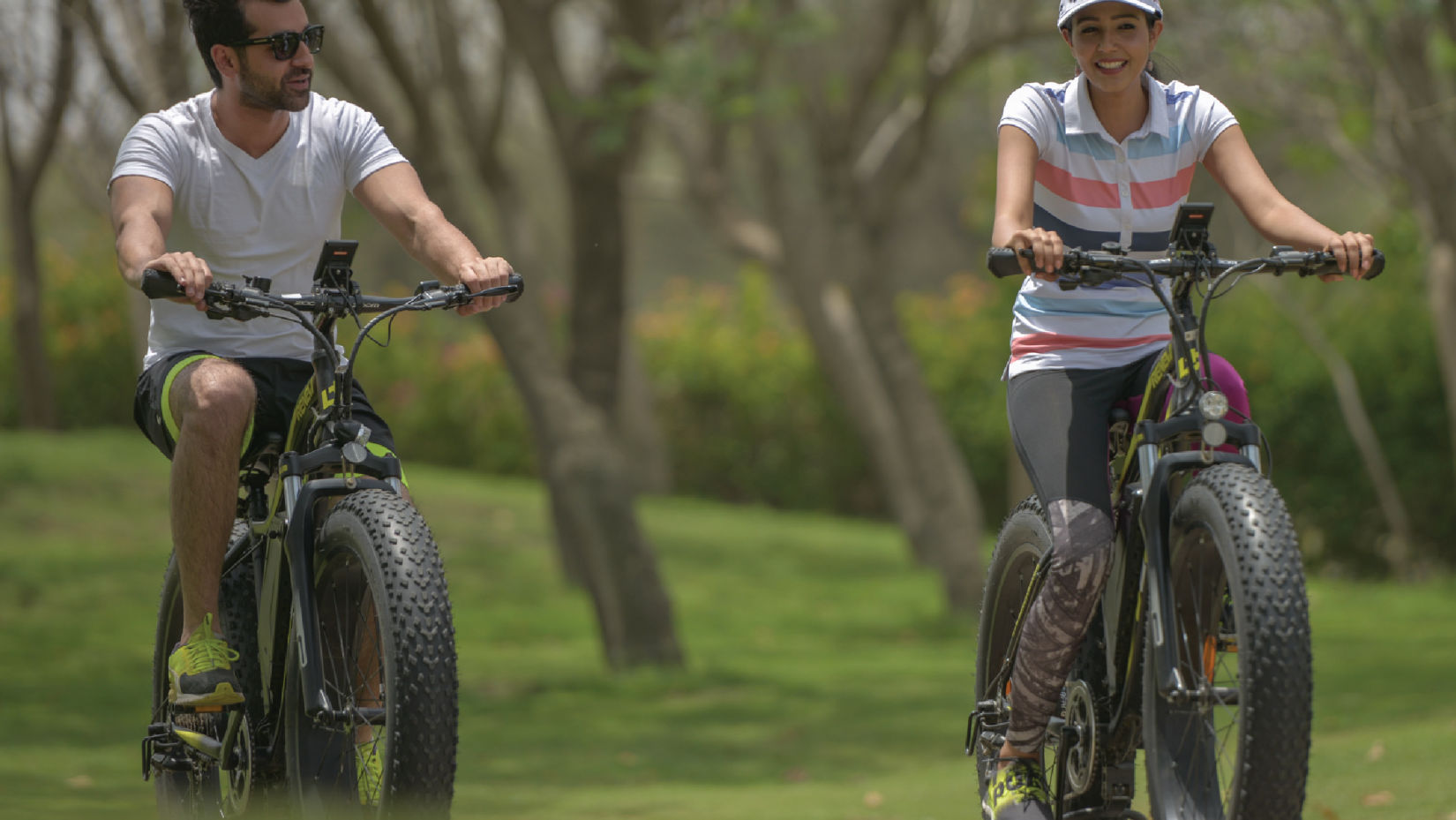 a couple cycling amidst lush green lawns