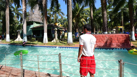 a life guard standing by a pool of water during daytime at our water park