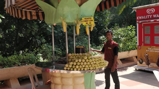 Water Kingdom - a man standing at bhutta stall at our water park