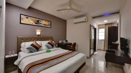 A executive room with a plush bed, modern amenities and an attached bathroom - Click Hotel Yuvraj, Surat