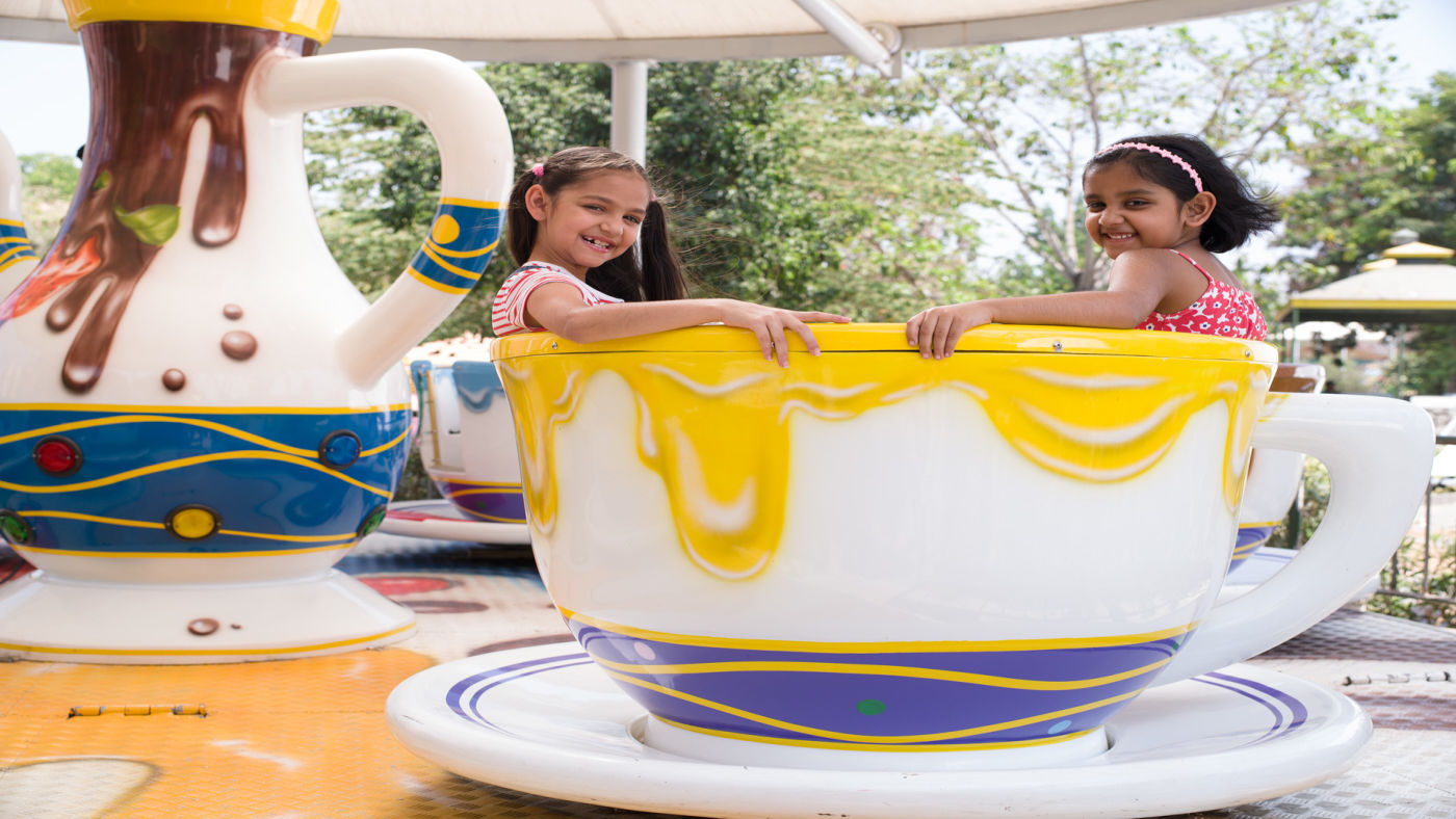 Kids seated in a cup-like platform