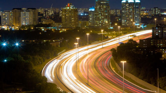 an image of a time lapse of car's headlights and taillights on a highway