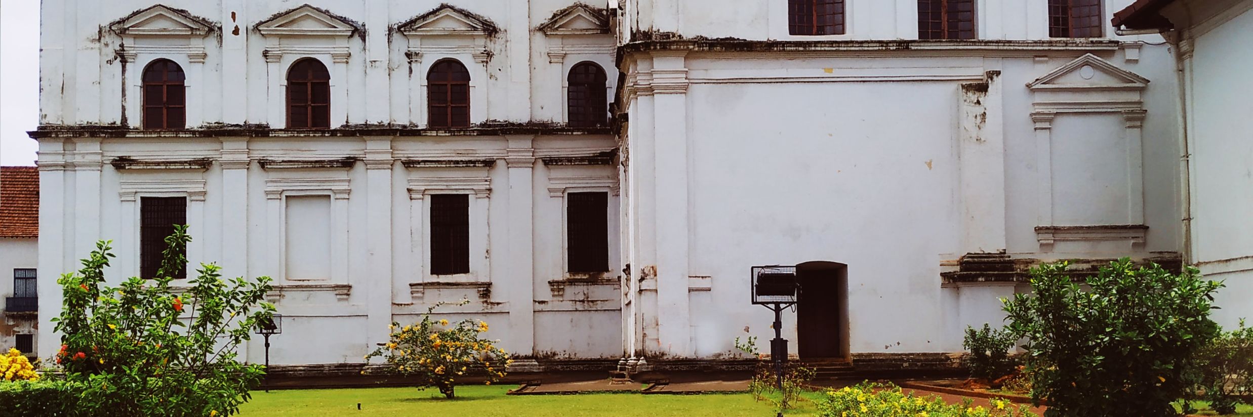 Exterior of Se Cathedral in Goa with a green lawn @ Lamrin Ucassaim Hotel, Goa