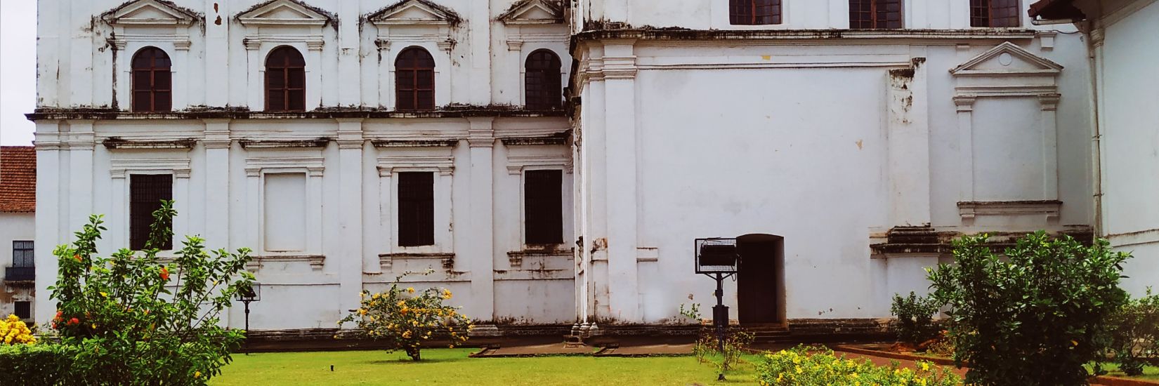 Exterior of Se Cathedral in Goa with a green lawn @ Lamrin Ucassaim Hotel, Goa