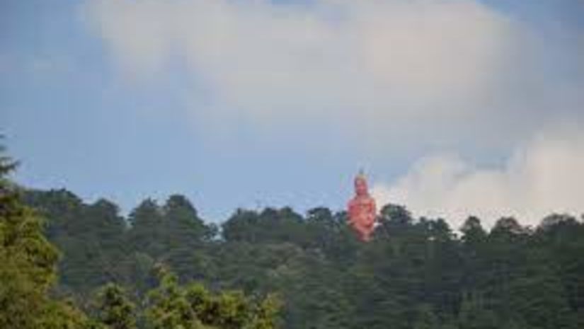 A red statue or monument visible amidst several trees