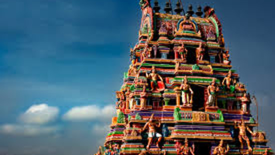 Facade image of a colourful temple with blue sky in the background