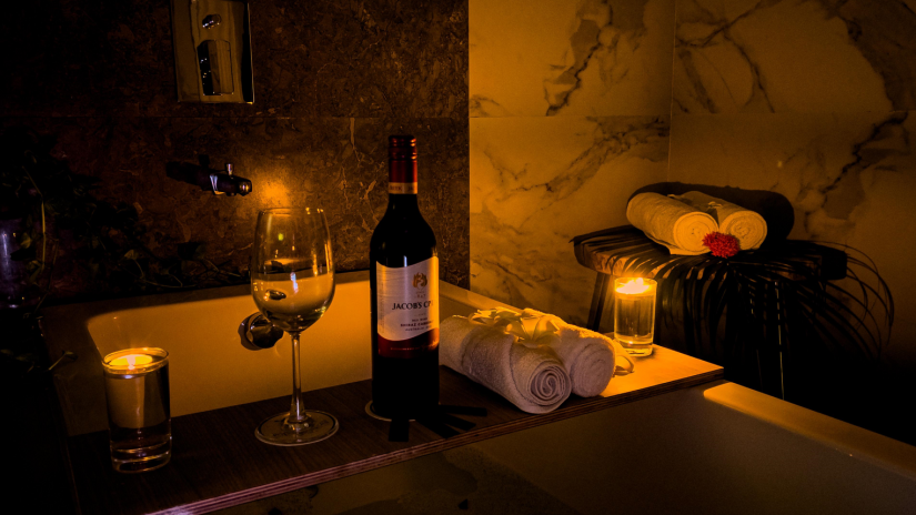 Candlelit bath with wine and towels