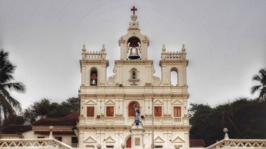 a white church building with stone carvings in Goa