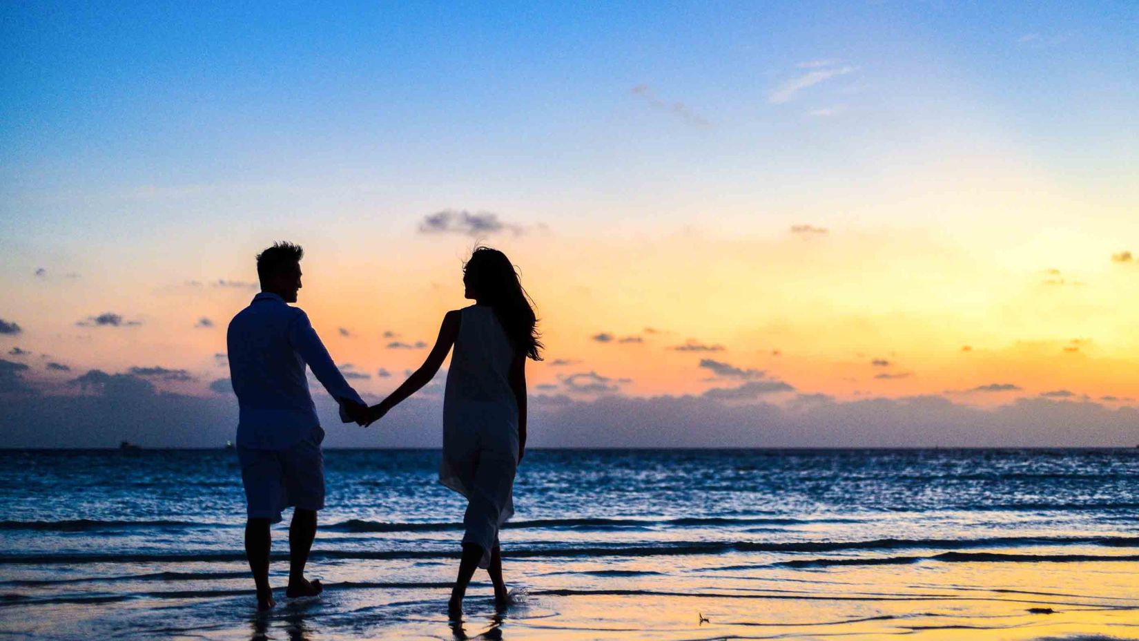 man-and-woman-holding-hands-walking-on-seashore-during-1024960