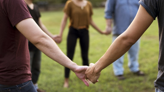 a group of people holding hands in a circle