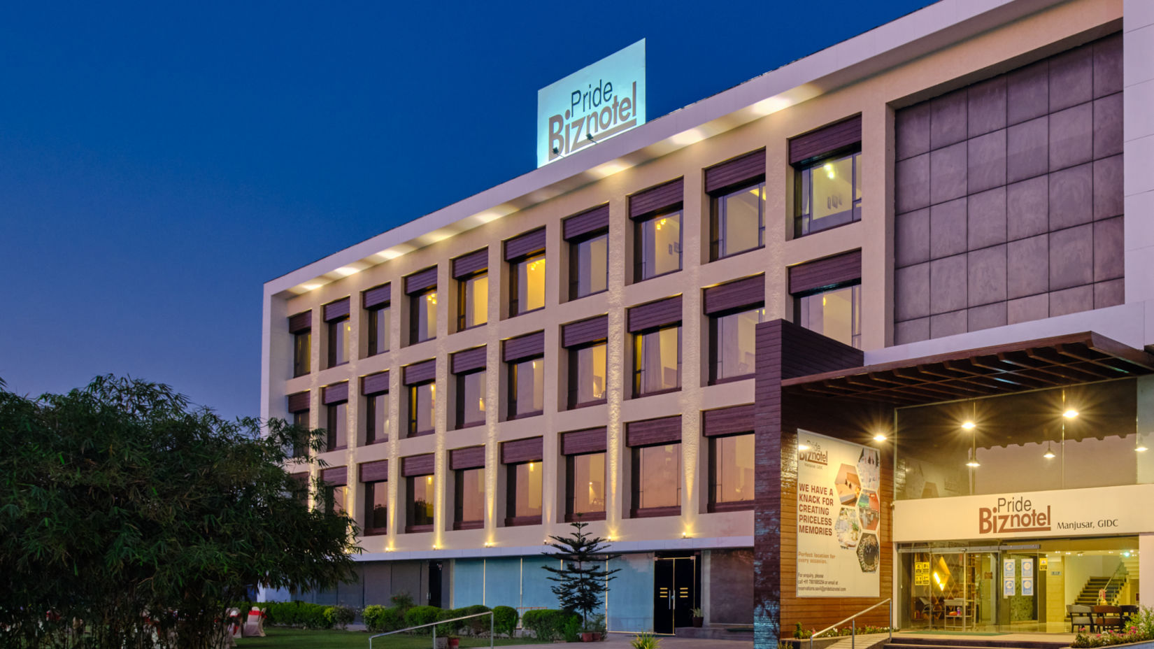 Pride Biznotel Manjusar - closer view of hotel exterior during evening