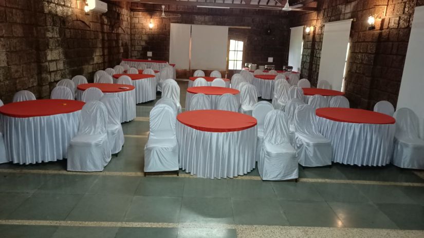 Lotus Eco Beach Resort Murud Beach-Dapoli District Ratnagiri - seating near a round table with projection screen behind at the Banquet Hall