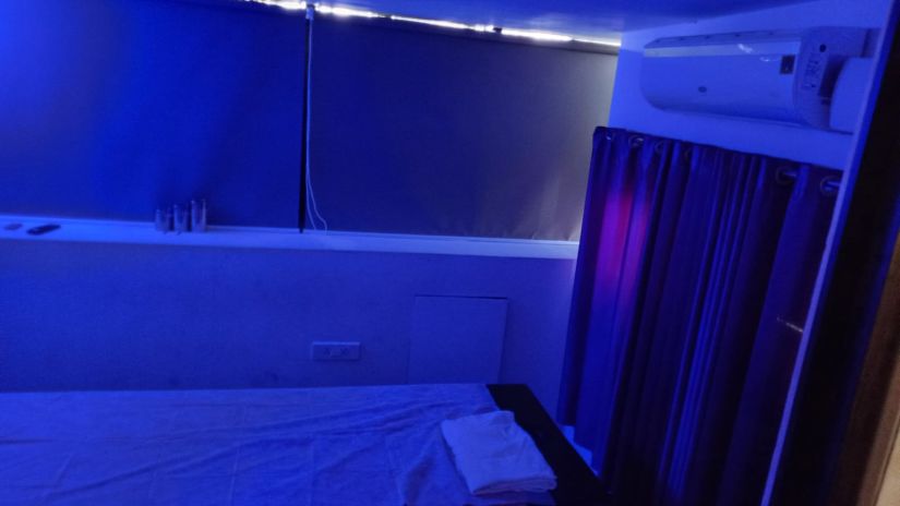 A Air-conditioned spa room illuminated in blue light with a bed to relax during spa treatments | The Terrace Business Hotel