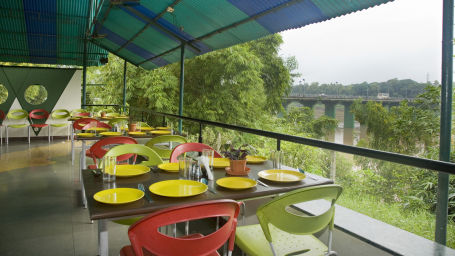 terrace seating with nature view inside a restaurant at VITS Kamats Resort, Silvassa