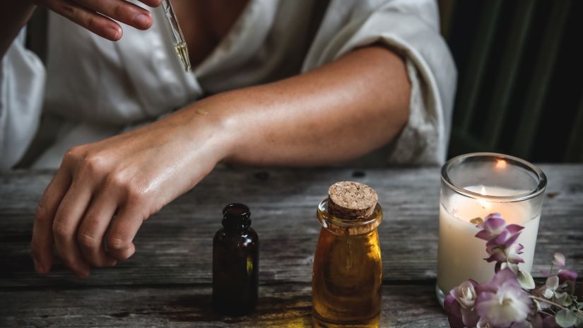 Image of a person pouring essential oil on their hand using a dropper