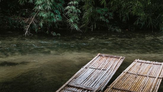 two-long-bamboo-rafts-by-the-side-of-a-shallow-river-3042375