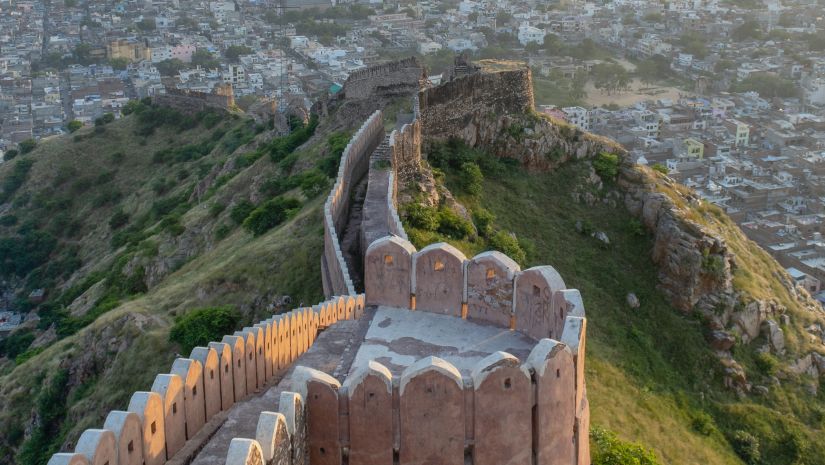 a bird's eye view of the Alwar Fort from above with greenery surrounding it