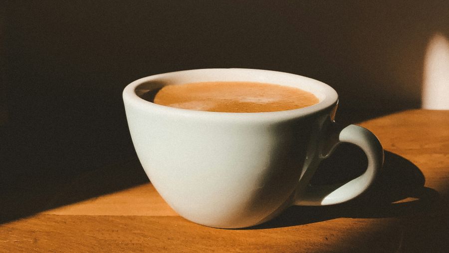 a cup of coffee placed on a wooden table