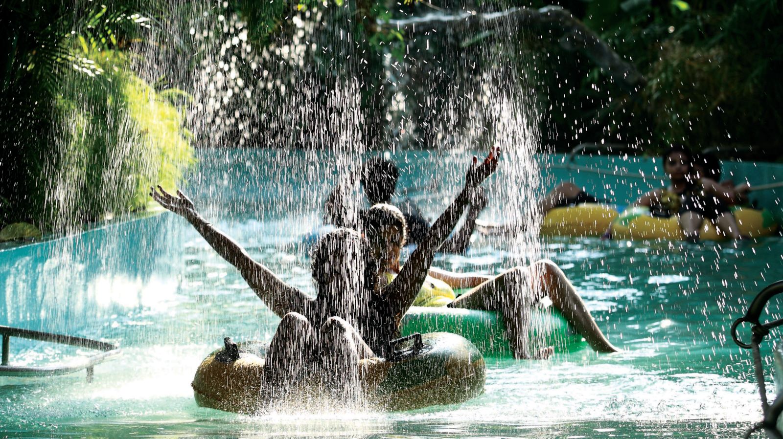 Water sparying as people float on water tubes