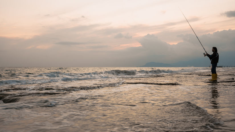 man fishing on the sea shore