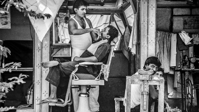 A person getting a shave from a street barber