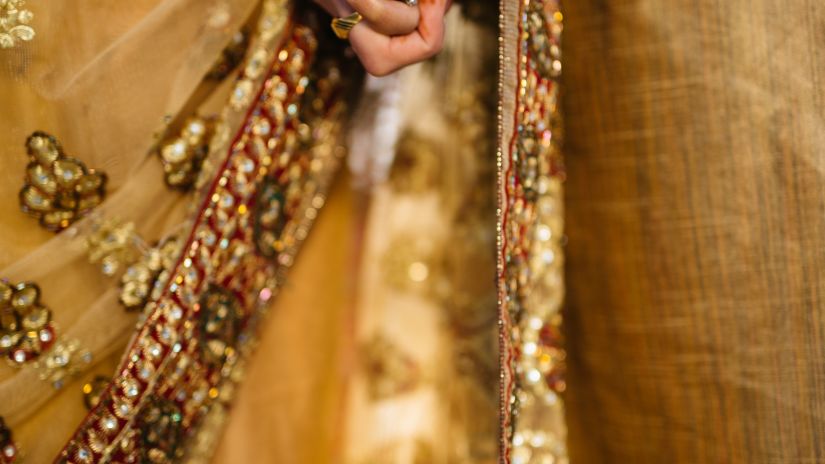 an image of a couple holding hands and wearing yellow outfits for a marriage ceremony