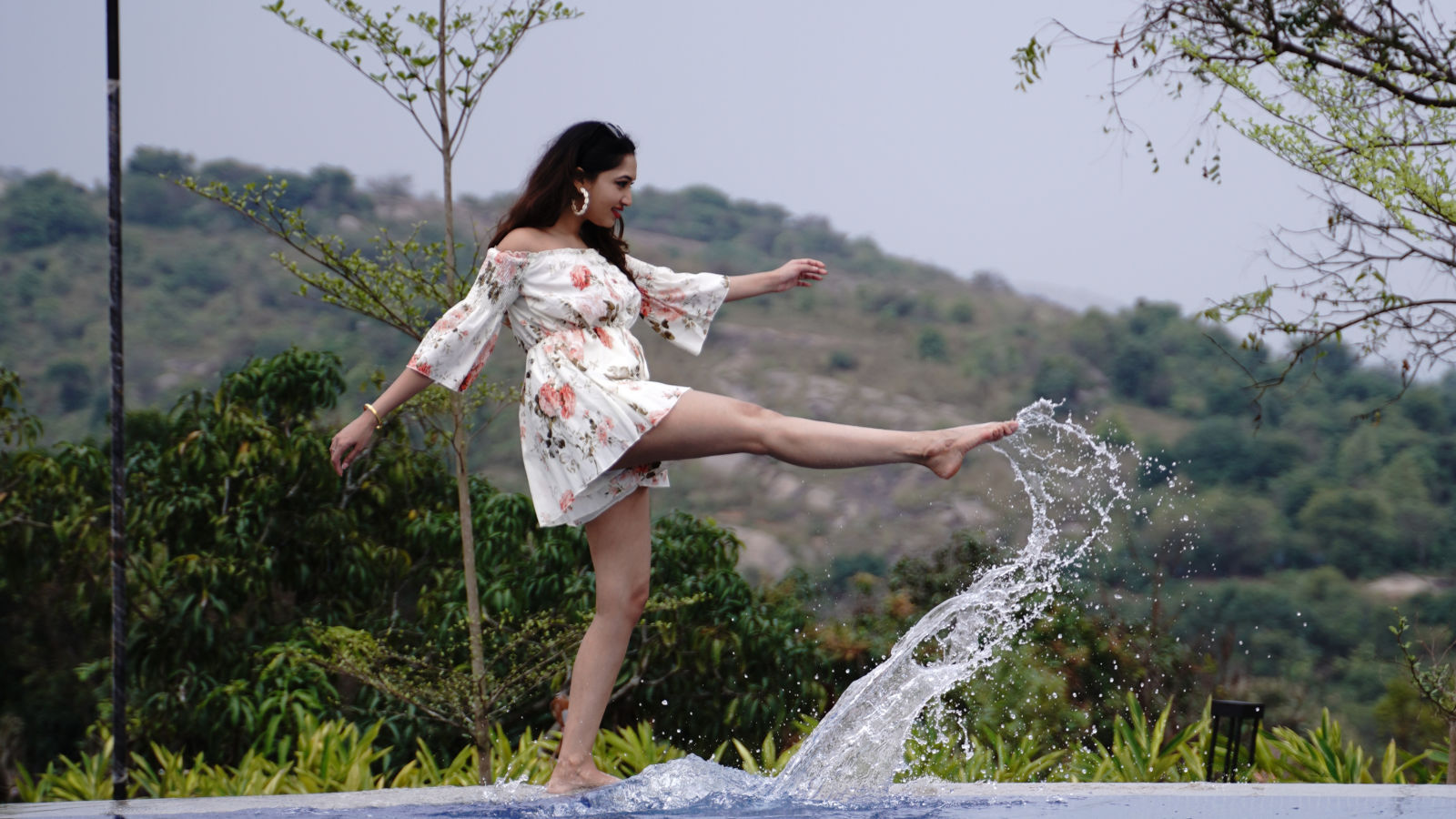 Ravishing Retreat Ramanagara - A guest splashing the water with her legs from the swimming pool