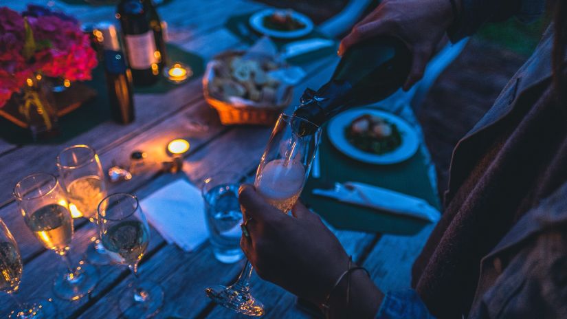 person pouring alcohol in a glass