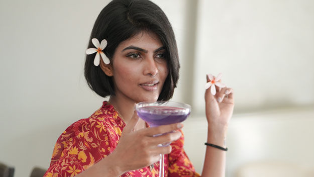 a girl holding a cocktail glass at The Residency Towers, Rameswaram