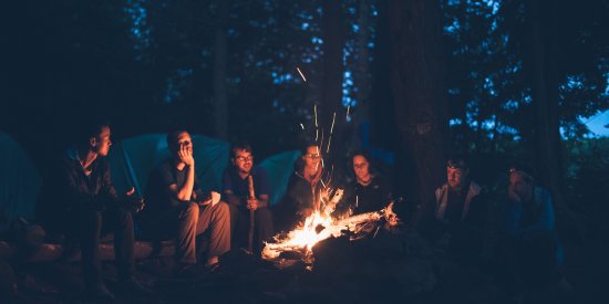 people sitting around a bonfire at night