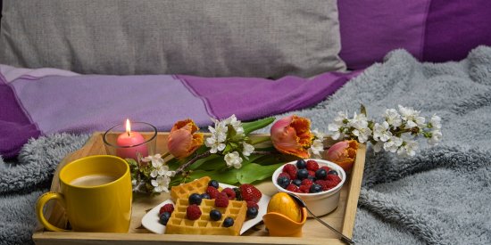 a tray filled with breakfast placed on a bed