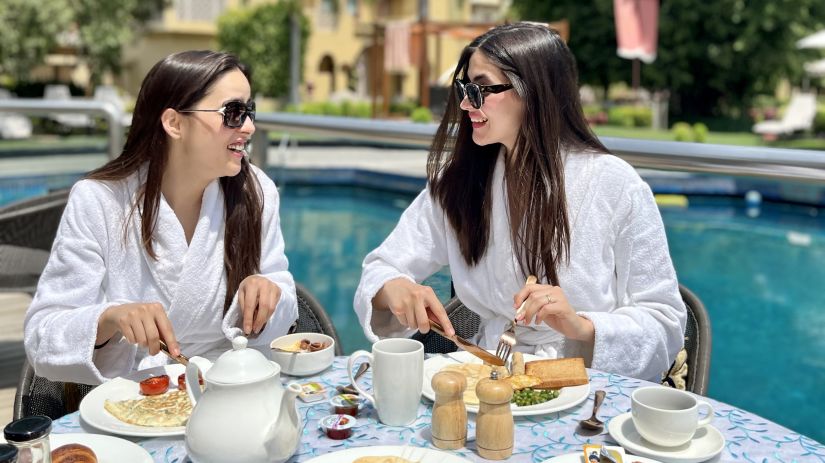 2 women enjoying a poolside breakfast spread - Heritage Village Resort & Spa, Manesar