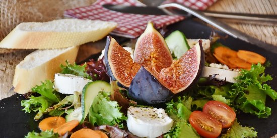 salad and bread served on a black plate