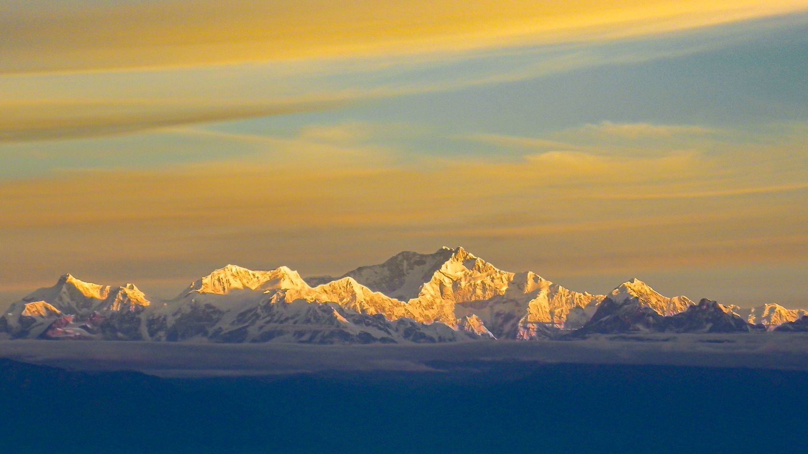 snow covered mountains with clouds above 