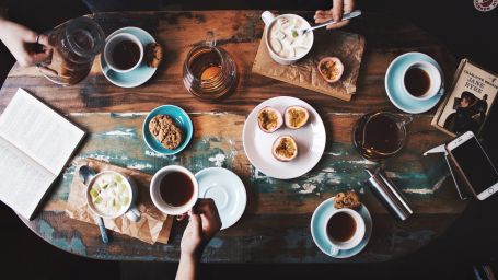 person-sitting-near-table-with-teacups-and-plates-2074130