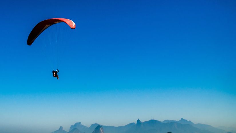 A person paragliding above the mountains