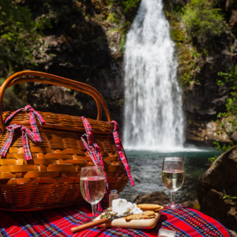 a picnic basket on a sheet with waterfall