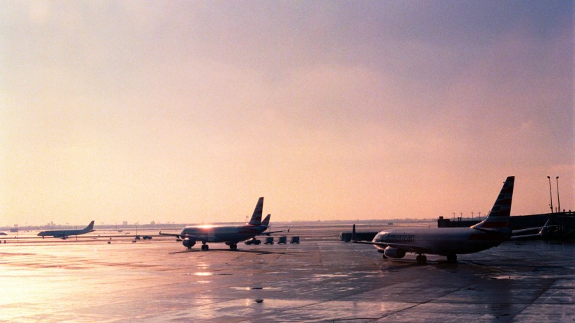 Planes ready to take off at runway with the sun rays shining on the road