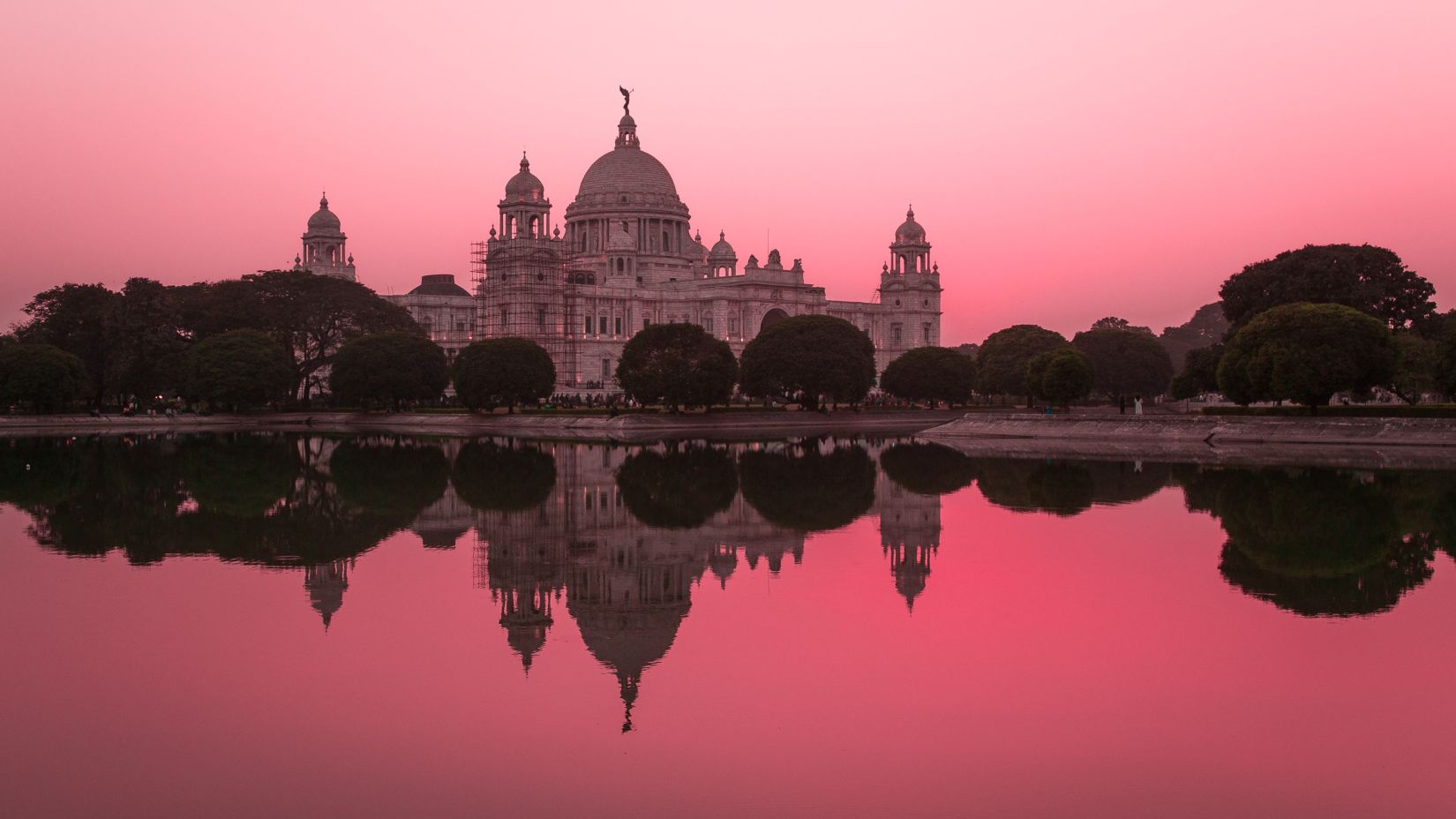 The beautiful Victoria Memorial in the pink sky overlooked from a river