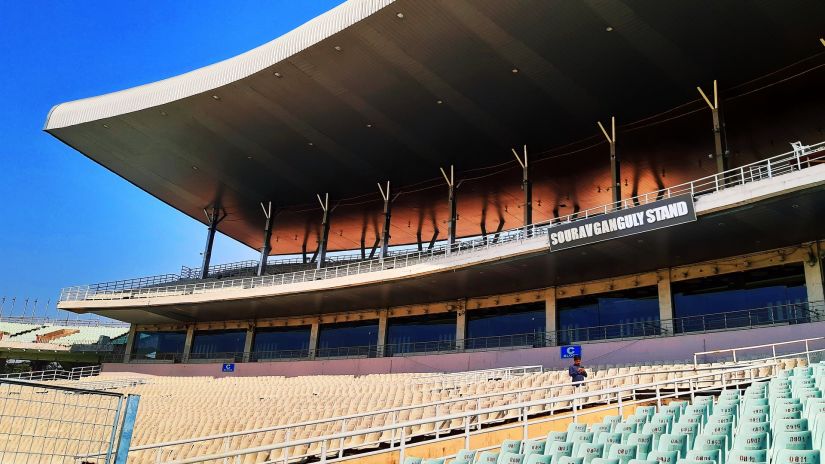 Empty seats in Eden Gardens cricket stadium with blue sky in the background