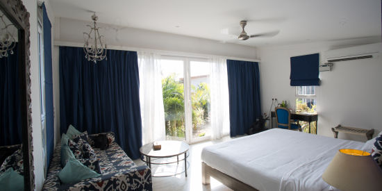 alt-text Hotel bedroom with glass door and a garden view