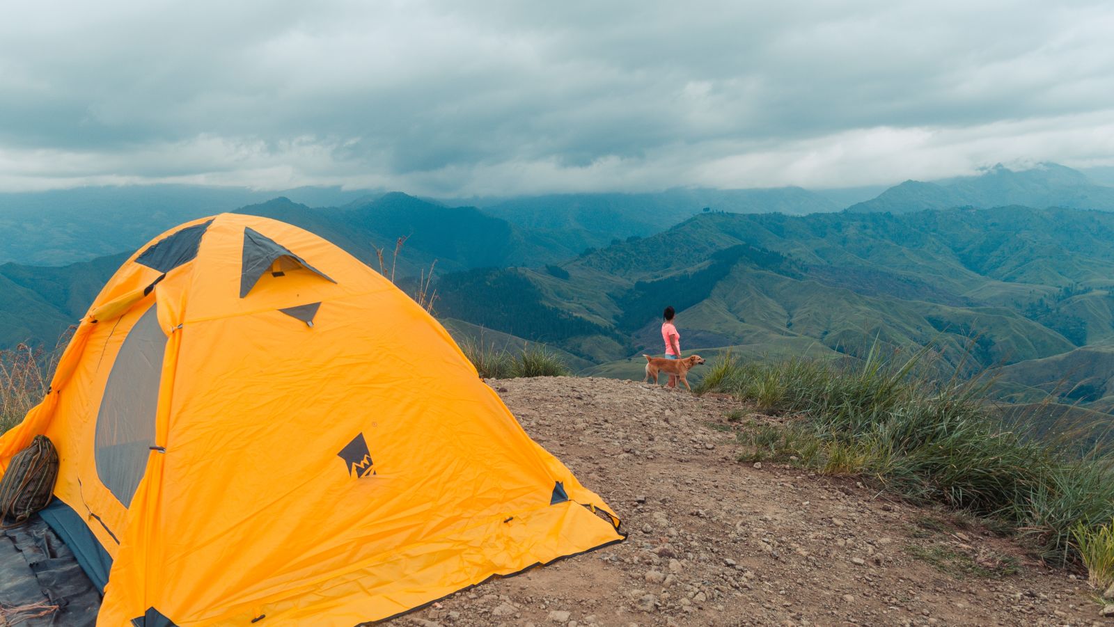 Yellow camping tent on a hill