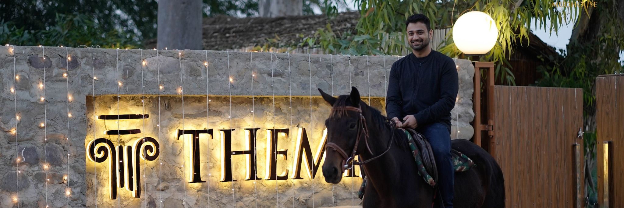 A man riding on a black horse at Themis Mudhouse - A Nature's Retreat Resort & Wellness